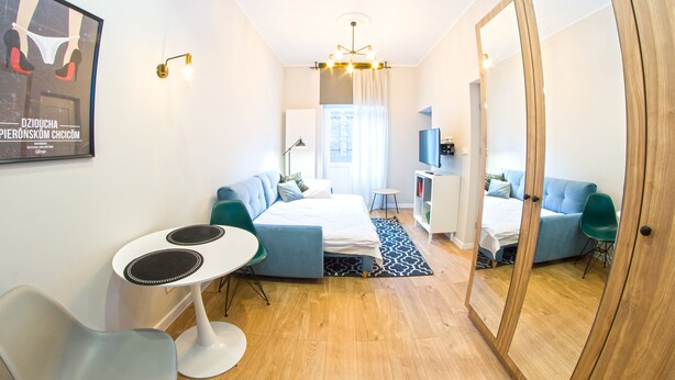 Una habitación moderna y bien iluminada con cama, zona de estar y una pequeña mesa.