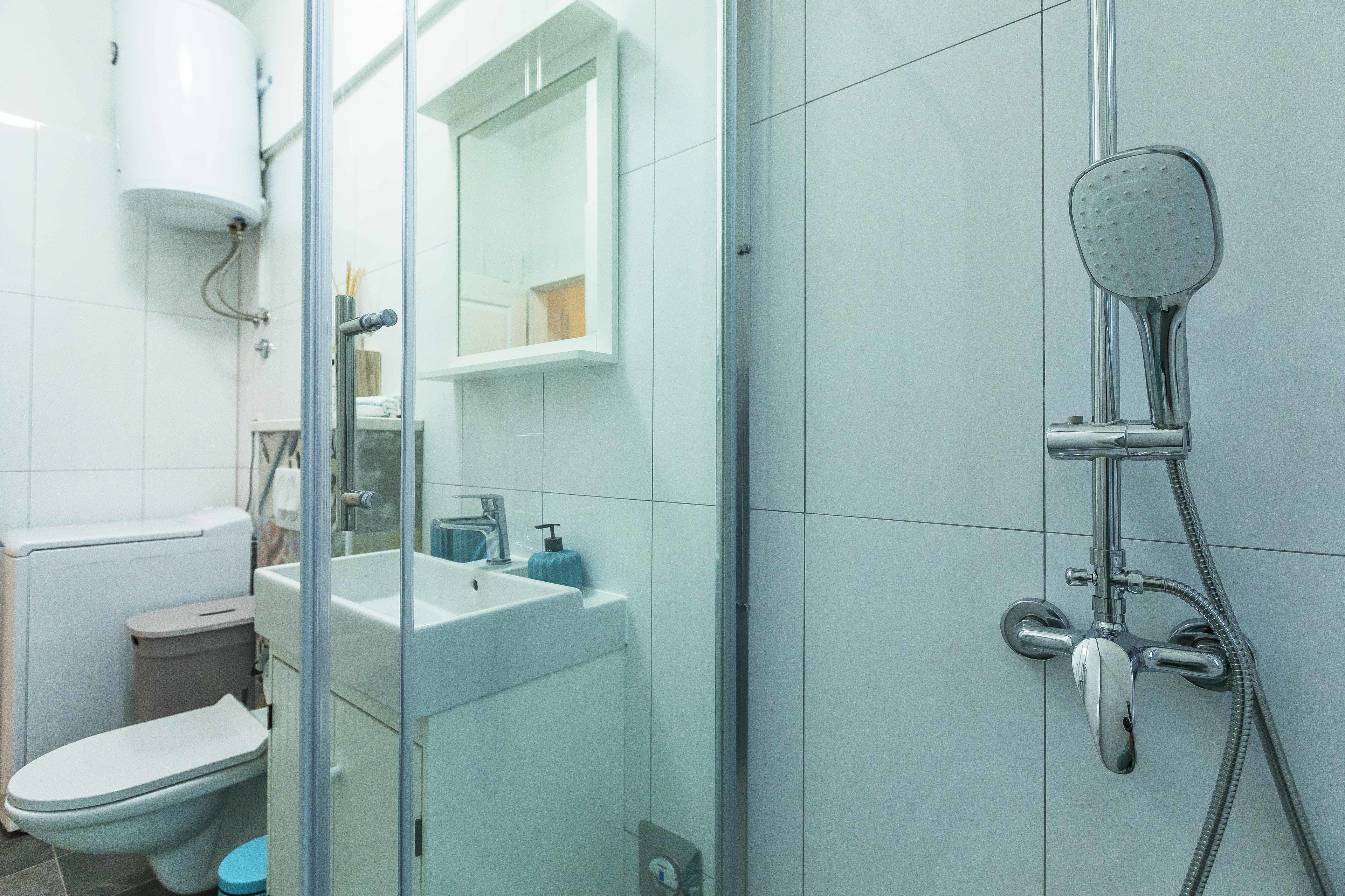 A modern bathroom with a toilet, sink, and shower.