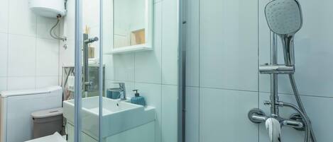 A modern bathroom with a toilet, sink, and shower.