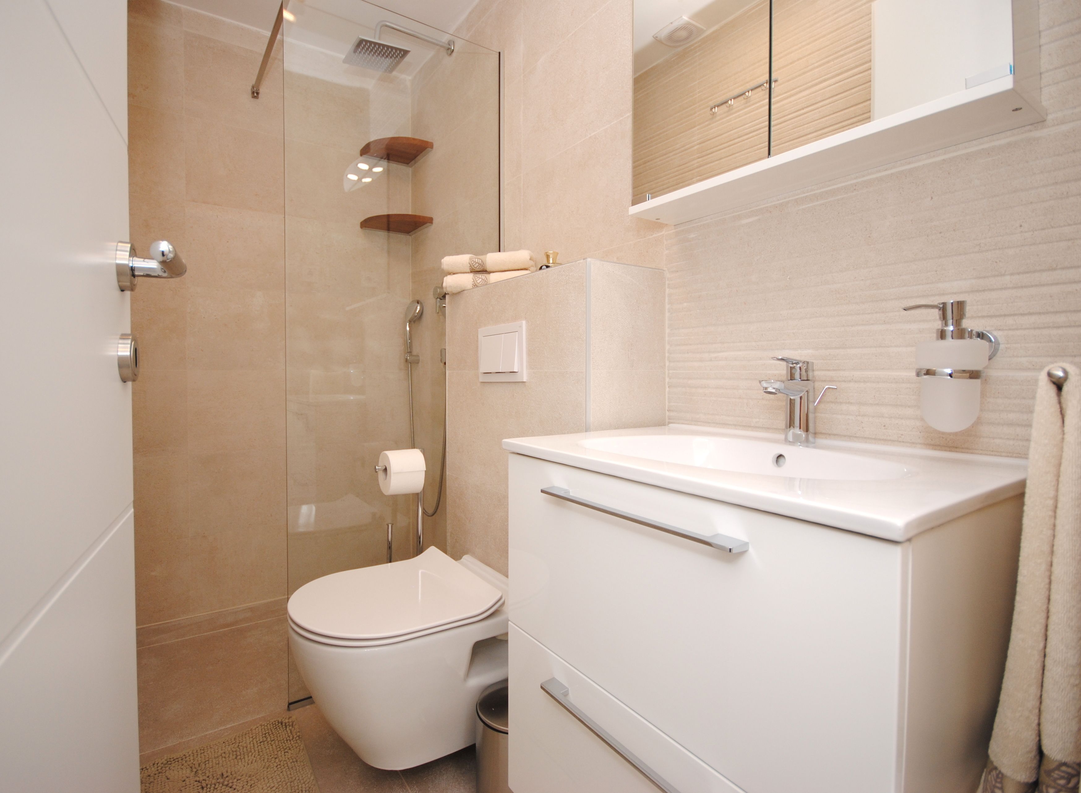 A modern bathroom with a toilet, sink, and shower.