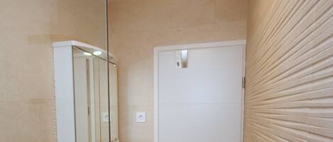 A compact bathroom with a white sink, mirror, and toilet.