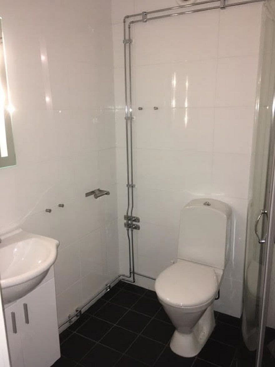 A bathroom with a white toilet, a sink, and a shower enclosure.