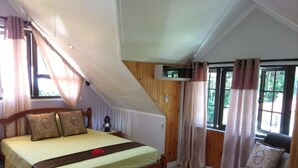 Ein Schlafzimmer mit einem hölzernen Bett, einer Couch und einem Fenster mit Vorhängen.