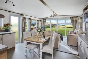 Une pièce spacieuse comprenant une table à manger, des chaises, un canapé et un coin cuisine.