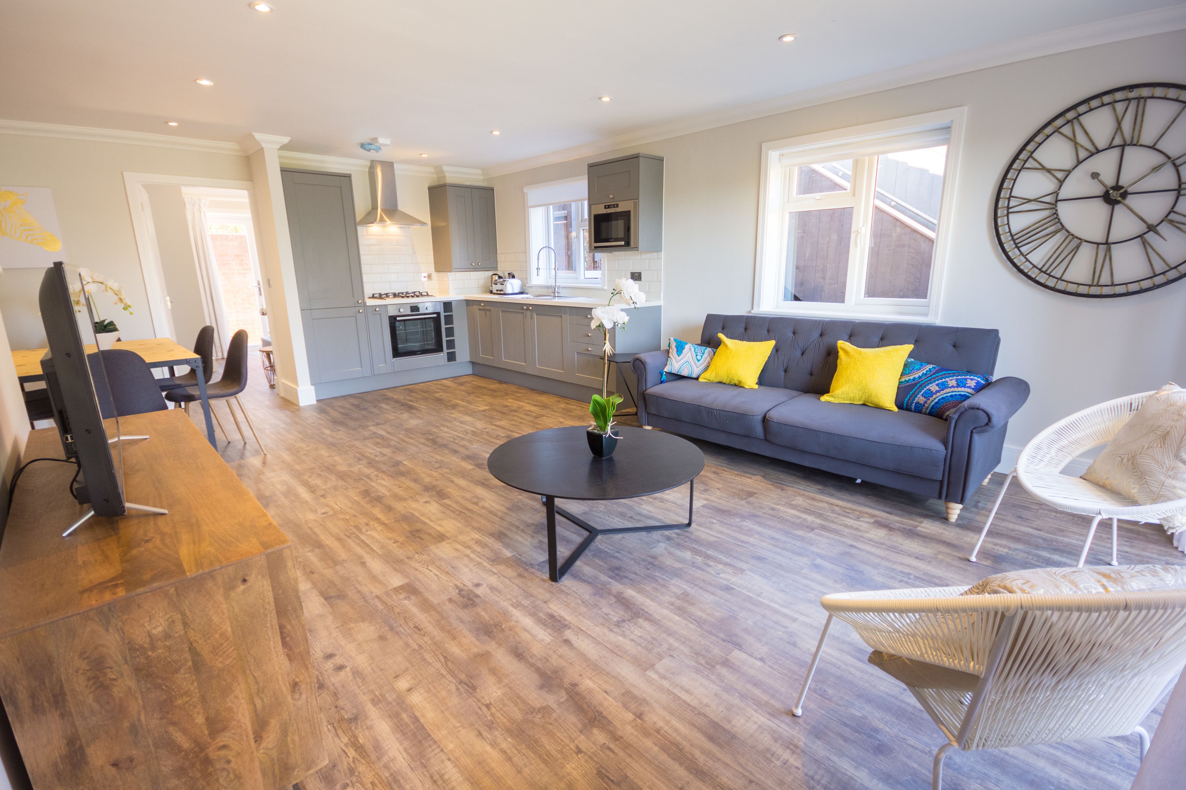 A modern living area with a sofa, coffee table, and dining table.