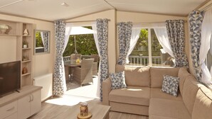 A cozy living room with a sofa, TV, and a coffee table. - St Helens Coastal Resort (Ryde)