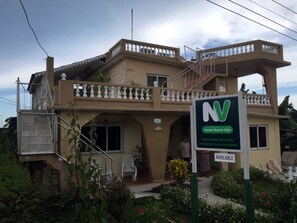 A two-story building with a balcony, a sign indicating availability, and a sign for 'Hostal Nueva Vida'. - Hostal Nueva Vida (Ciénaga de Zapata)