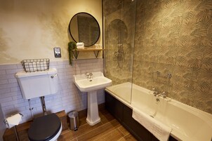 A bathroom with a toilet, sink, and bathtub.