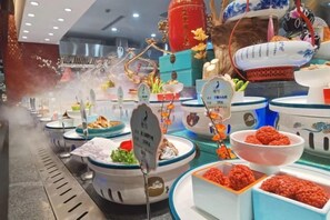 A buffet with various dishes and a steam vent.