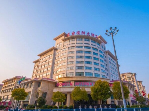 Un hotel de varios pisos con una señalización destacada que indica 'Dongtai International'.
