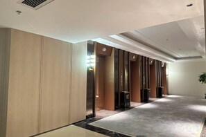 A hotel lobby with a marble floor, wooden paneling, and a reception desk.