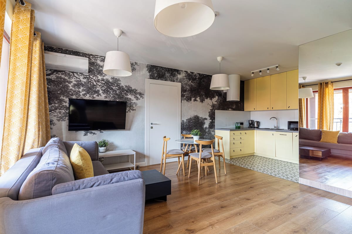Una sala de estar moderna con un sofá, televisor y comedor.
