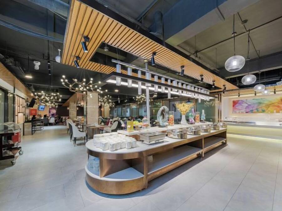 A modern interior with a central display counter, high ceilings, and a mezzanine level.