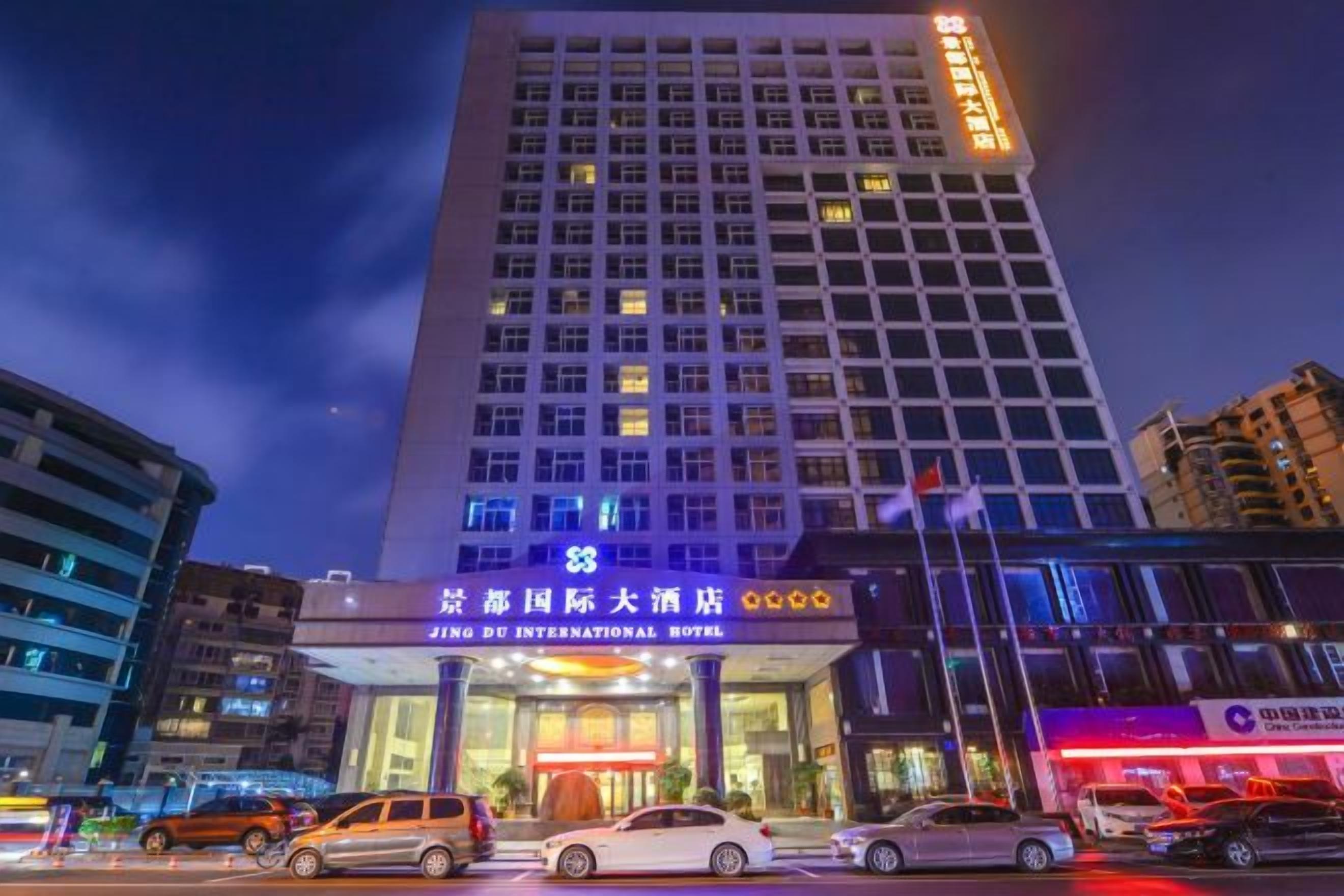 A multi-story building with illuminated signage for the Jing International Hotel.
