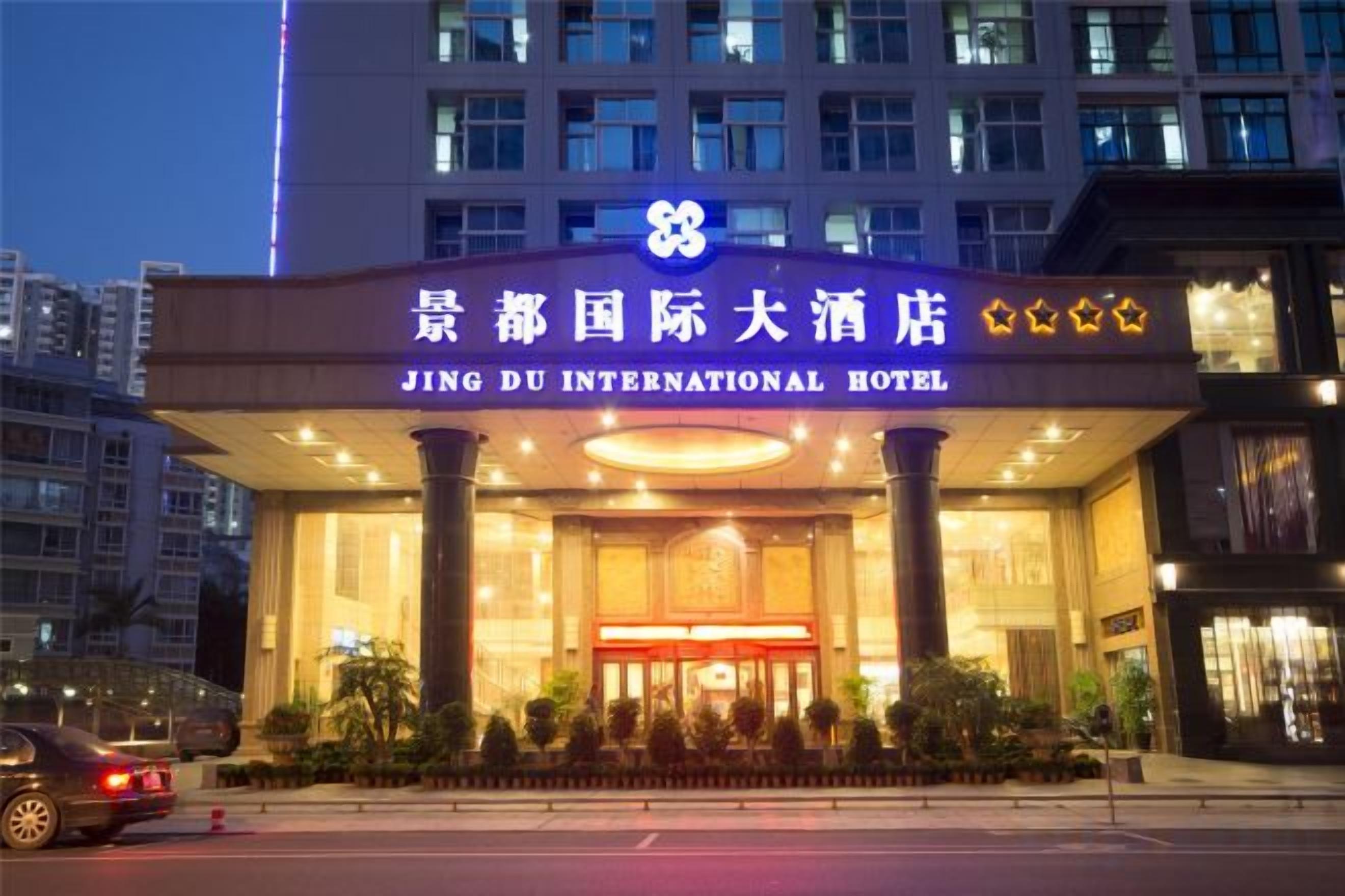 Das äußere Erscheinungsbild des Jing Du International Hotels mit einem markanten Eingang und Beschilderung.