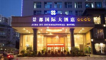 Das äußere Erscheinungsbild des Jing Du International Hotels mit einem markanten Eingang und Beschilderung.