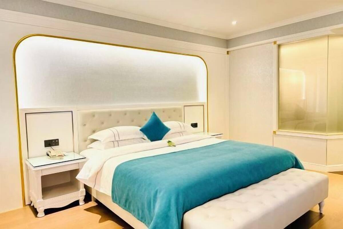 Une chambre à coucher moderne avec un grand lit, une table de chevet et une armoire.