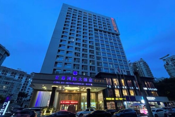 A multi-story hotel with a prominent entrance and signage for 'Jing Du International Hotel.'