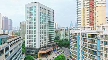 Un edificio de gran altura con varios pisos, un patio central y edificios modernos circundantes.
