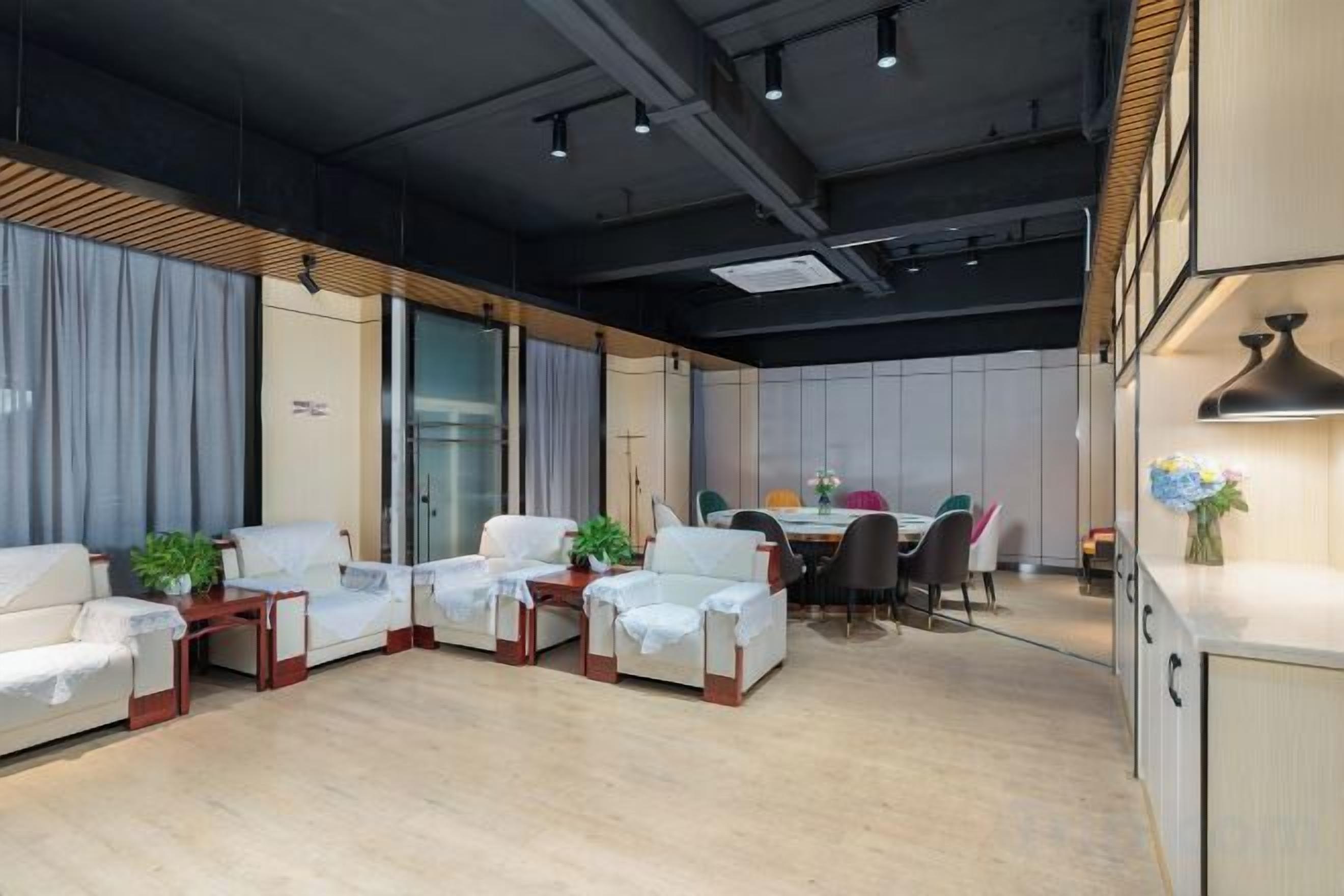 A modern interior with a seating area, a dining table, and a kitchenette.