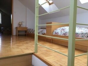 Cozy retreat with a sloped ceiling, featuring a bunk bed, nightstand, and dresser.
