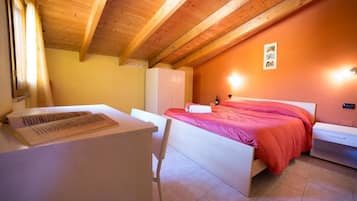 Een slaapkamer met een houten plafond, een bed met een rode spreideken, een wit bureau en een witte stoel.