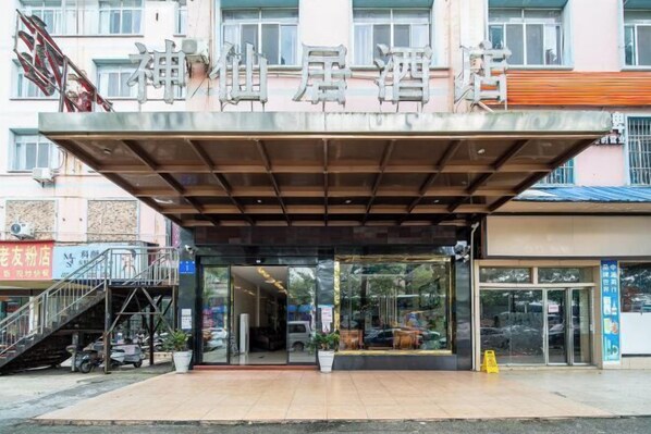 Entrada de hotel con acceso cubierto y una escalera que lleva a un piso superior.