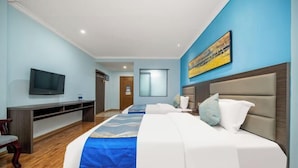 A hotel room with a large bed, a TV mounted on the wall, a desk, and a painting above the bed. - Nanning Shenxianju Hotel (Jiangnan Passenger Transport Terminal) (Nanning)