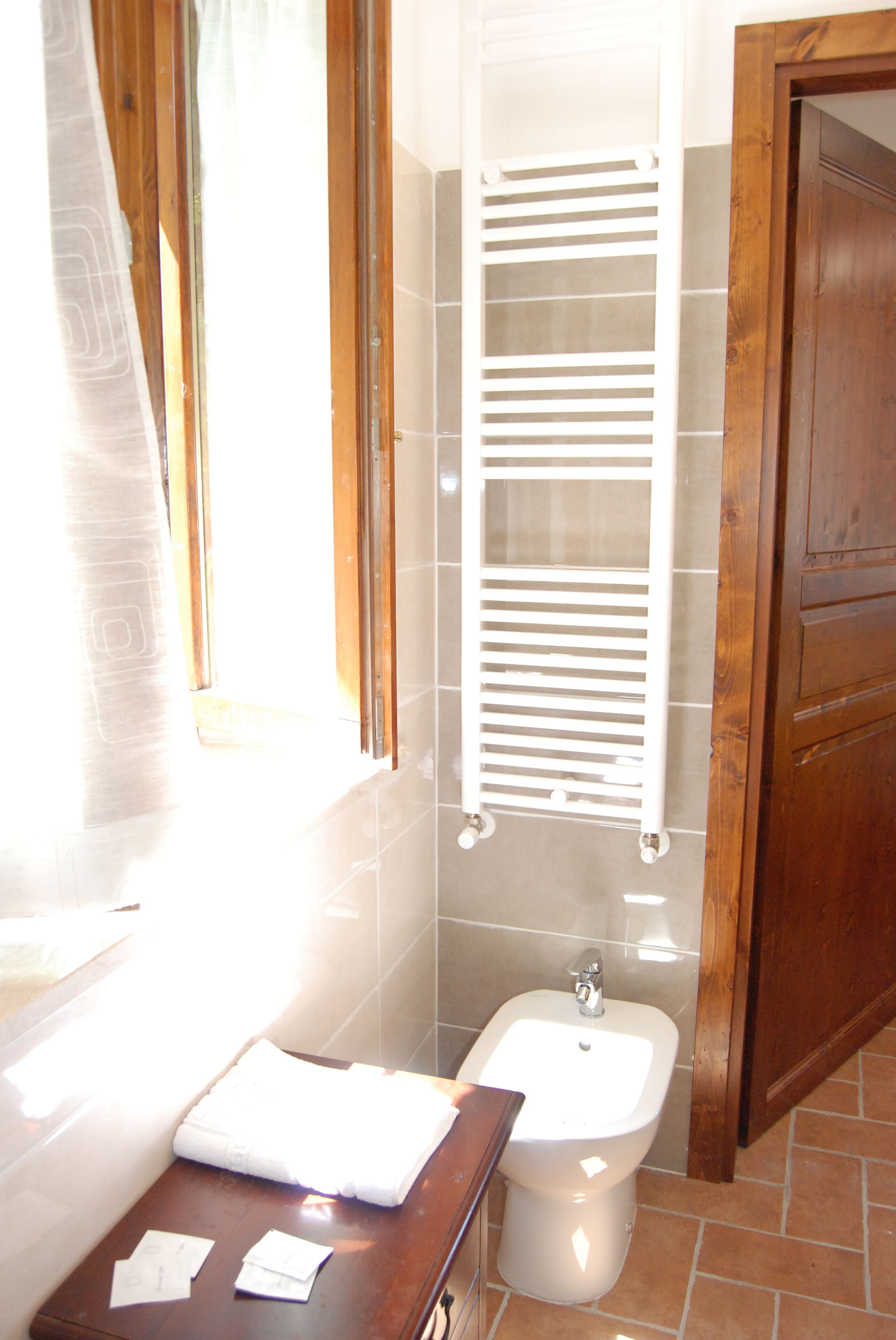 Un baño con bidé, un perchero y una puerta de madera.
