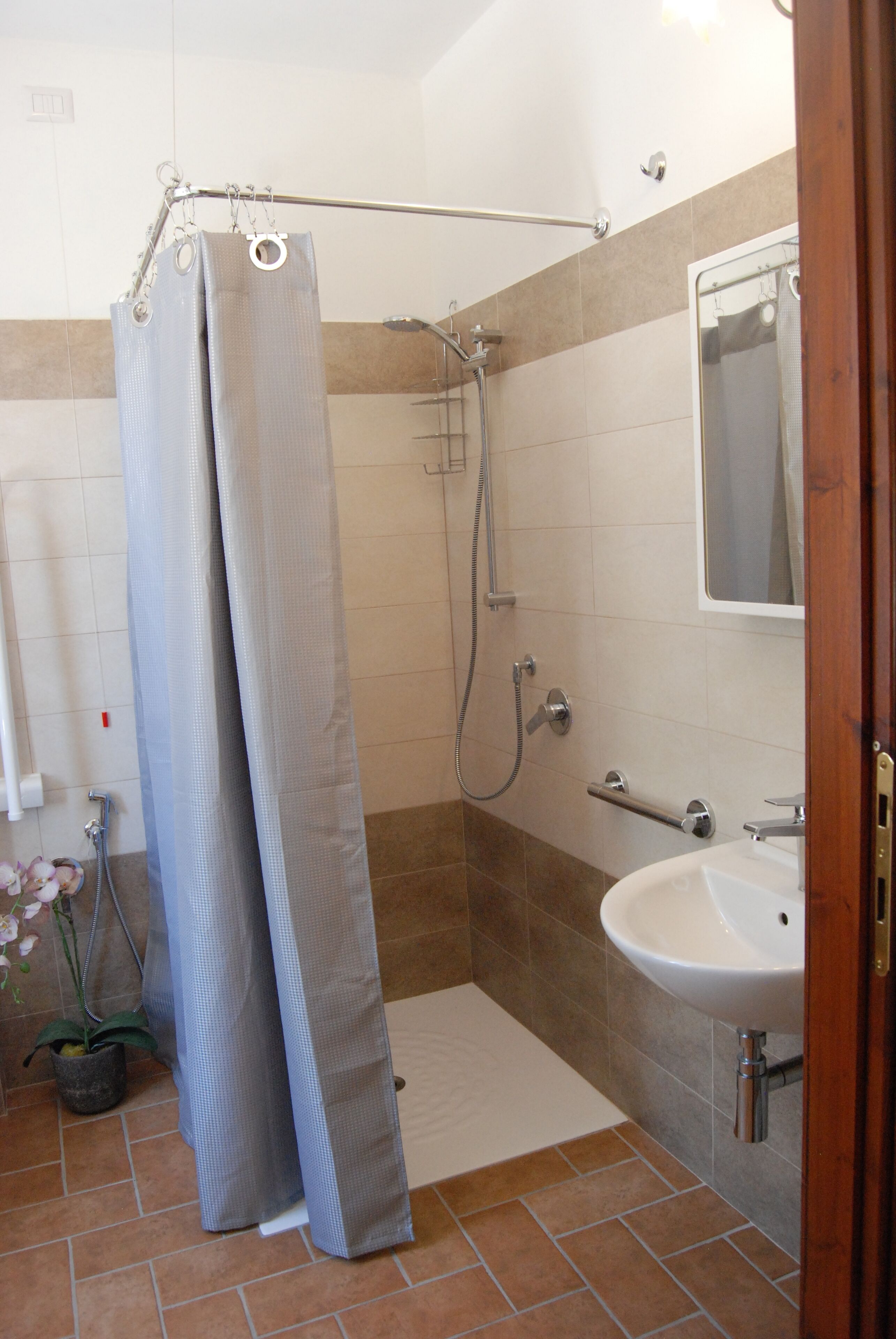 Ein Badezimmer mit Dusche, Waschbecken und Spiegel.