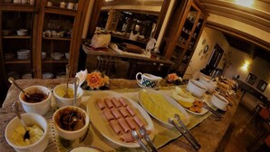 A buffet setup with various dishes, including sliced meats, cheeses, and fruits. - Engenho da Lagoa Pousada (Garopaba)