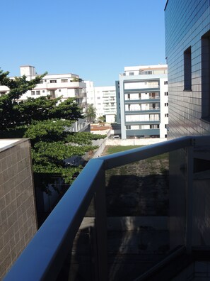 Blick auf ein modernes Mehrgeschosshaus mit Balkon und blauem Himmel.