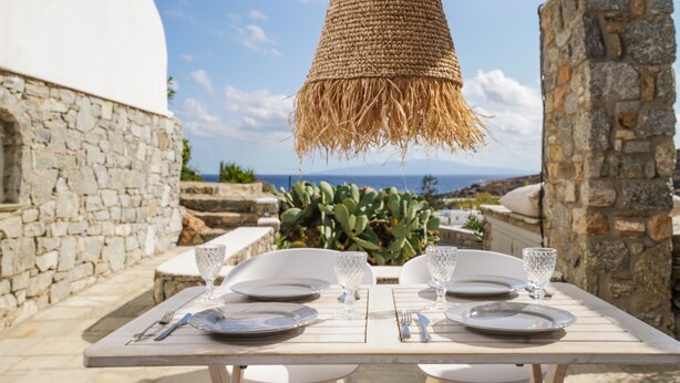 An outdoor dining area with a table set for two, overlooking a scenic view. - VLIA MAR Myconian Residences (Mykonos)