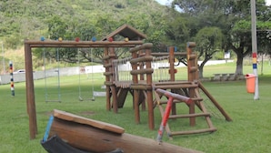 A playground with a wooden climbing structure and a seesaw. - Casa Cabo Frio Aconchegante 5min Praias (Cabo Frio)