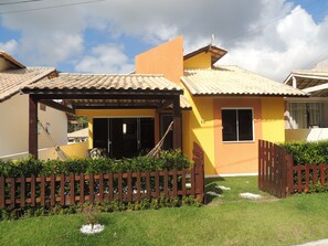 A residential house with a tiled roof, a wooden fence, and a well-maintained lawn.