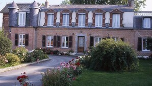 A two-story brick house with a central entrance, a driveway, and a garden with flowers. - Chambres d’hôtes d'Origny-en-Thierache (Origny-en-Thierache)