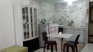 A compact living space with a dining area, a kitchenette, and a small seating area.