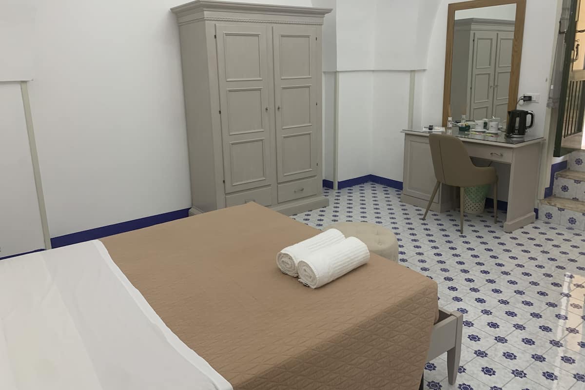 Un dormitorio con cama, escritorio, silla y armario.