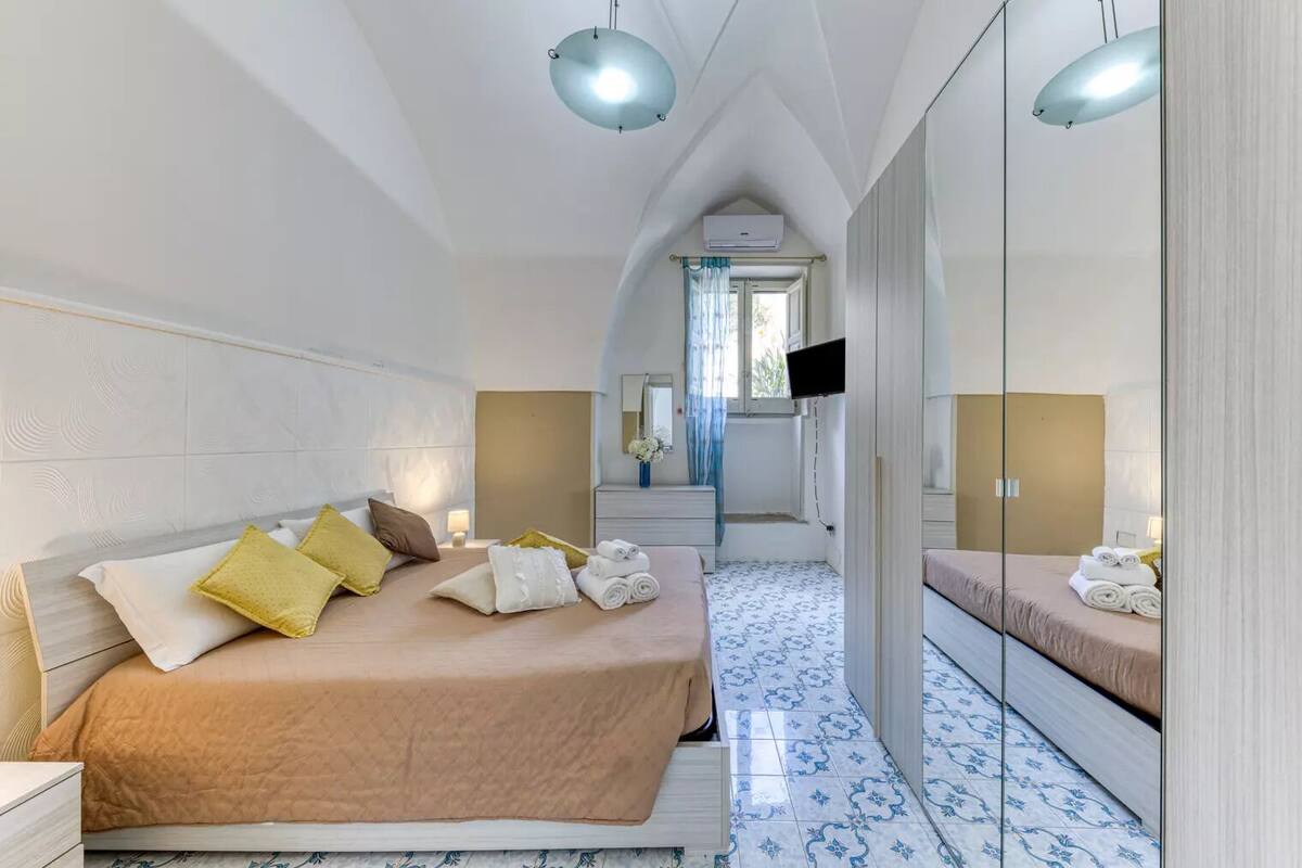 Una habitación de hotel moderna con una cama grande, un televisor y un espejo.