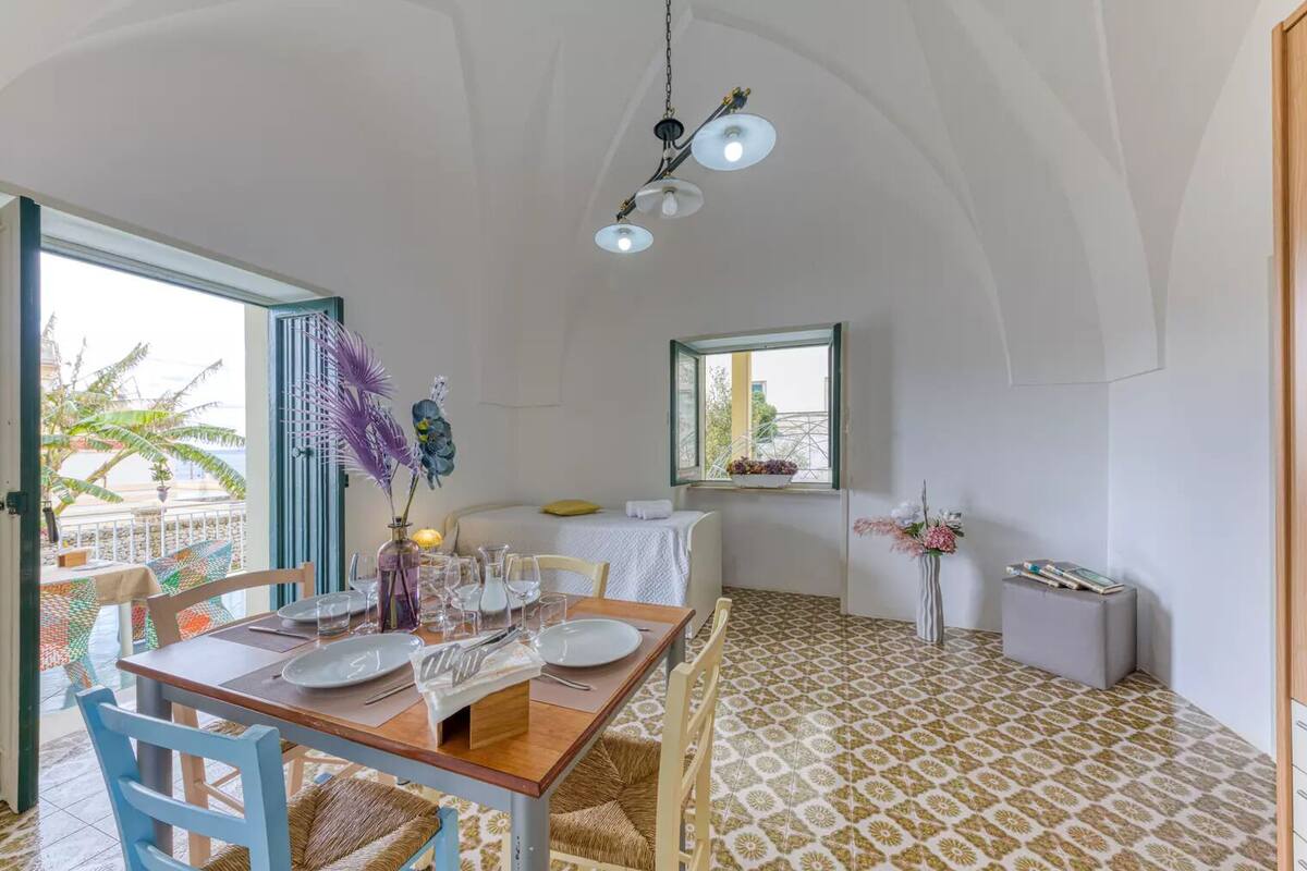 Comedor con mesa para cuatro, ventana con vistas y suelo con estampado.