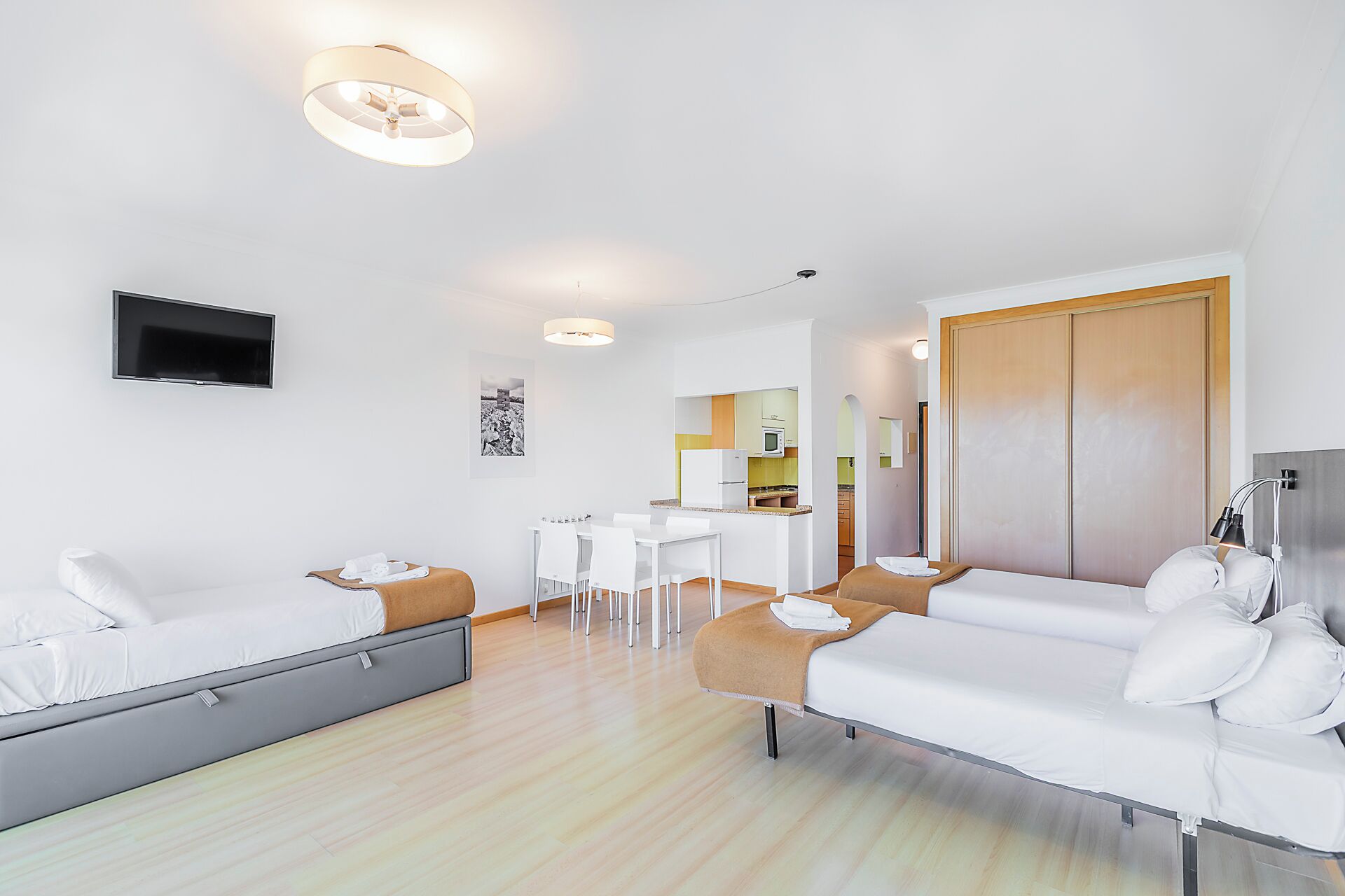 Una habitación de hotel moderna con cama, sofá, escritorio y kitchenette.