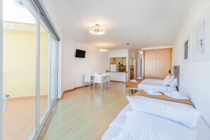 Une chambre d’hôtel équipée d’un lit, d’un bureau, d’une chaise, d’une télévision et d’un coin cuisine.