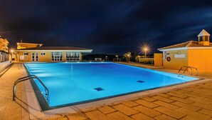 A swimming pool with a clear blue water surface, surrounded by a brick deck. - HI Santa Cruz - Pousada de Juventude - Hostel (Torres Vedras)