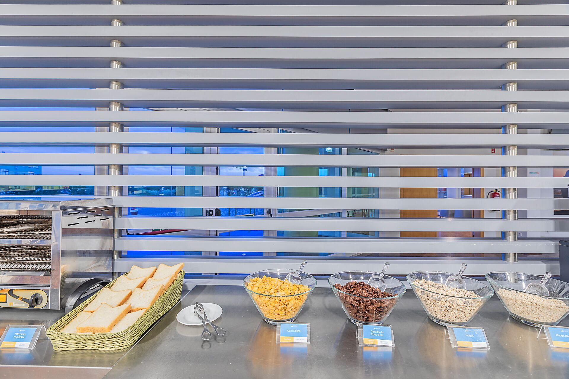 A buffet with various food items and a wicker basket of bread.