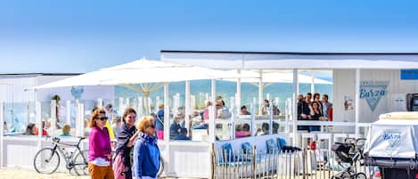 En bar vid stranden med uteservering och ett överbyggt område.