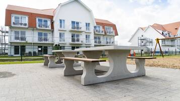 A park with picnic tables and a playground.