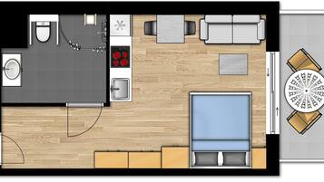 Planta baixa de um quarto de hotel, incluindo uma cama, banheiro, cozinha compacta, área de refeições e um pequeno espaço de estar.