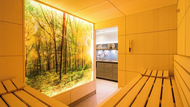 A modern bathroom with a large window, wooden benches, and a visible sink area.