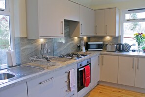 Apartamento, 3 quartos | Cozinha privada | Geladeira grande, micro-ondas, fogão, lava-louças