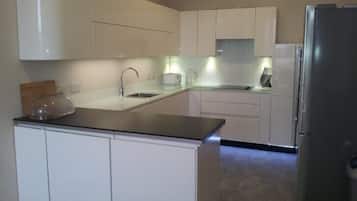 Apartamento, 3 quartos | Cozinha privada | Geladeira, micro-ondas, fogão, lava-louças